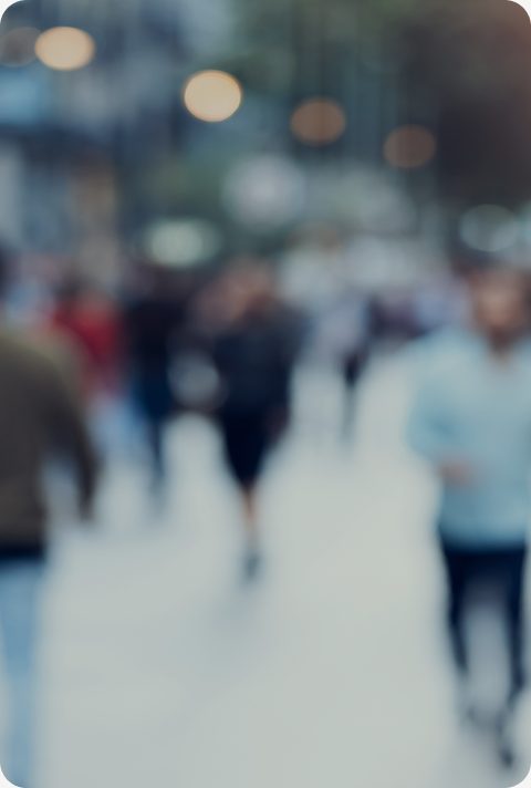 People walking along a busy city street, blurred