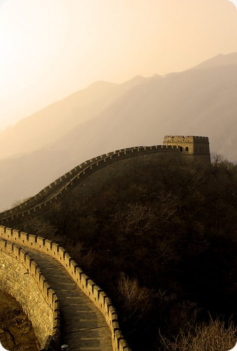 The Great Wall of China winding over hills at sunset